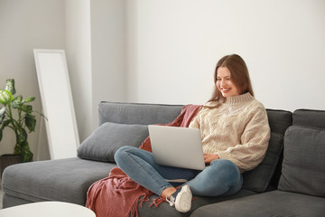 Naklejka premium Happy woman with laptop resting at home