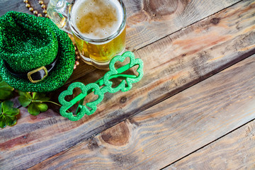 St. Patricks Day green shamrocks with a full cold frosty glass of beer  background