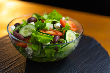 Closeup of freshly made, tasty, delicious, low fat, healthy salad set on a wooden table.