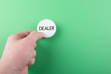 hand pressing dealer button - green background