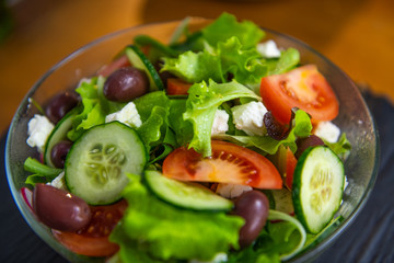 Extreme closeup of freshly made, tasty, delicious, low fat, healthy salad set on a wooden table.