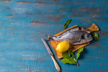 Rustic style. Fish food. Herring fish on an old blue wooden background and copy space for text.