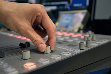 Mano controlando volumen en estudio de radio