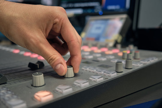 Mano controlando volumen en estudio de radio