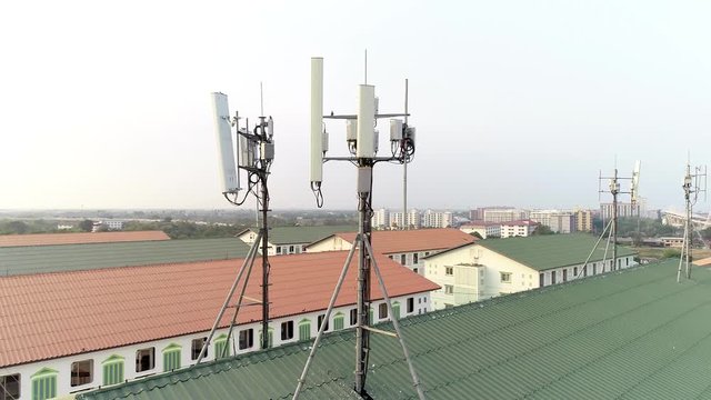 Aerial orbit of antennas on rooftop in residential area of Pathum Thani