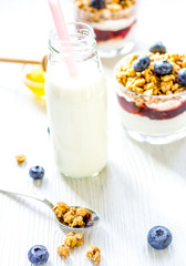 Fitness breakfast with muesli, honey and milk on white table
