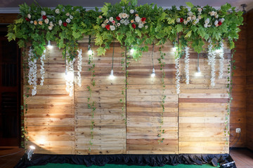 Beautiful photo booth zone at wedding or birthday reception. holiday photobooth decor with wooden boxes, flowers, and lights