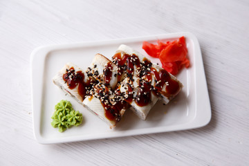 eel rolls on a light wooden background
