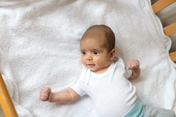 Newborn baby. A little boy in white clothes. Beautiful portrait of a toddler. Big-eyed baby.