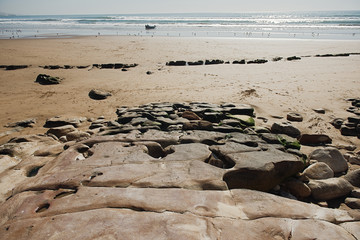 seashells and stones on a front coast of the ocean and sky and fishing boat