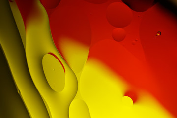 Beautiful abstract background of red and yellow curves. Drops of oil in water.