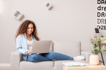 Young African-American woman with laptop working at home