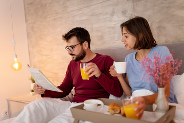 Obraz na płótnie Canvas Couple having breakfast and reading newspapers