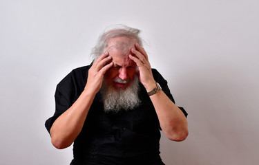Old man in mental pain.Elderly gentleman is suffering from mental anquish.Senior man in terrific mental pain. .. .Mature gentleman with a newsboy cap and black guayabera shirt and long white beard..