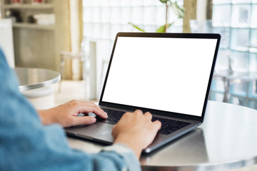 Mockup image of a woman using and typing on laptop computer with blank white desktop screen