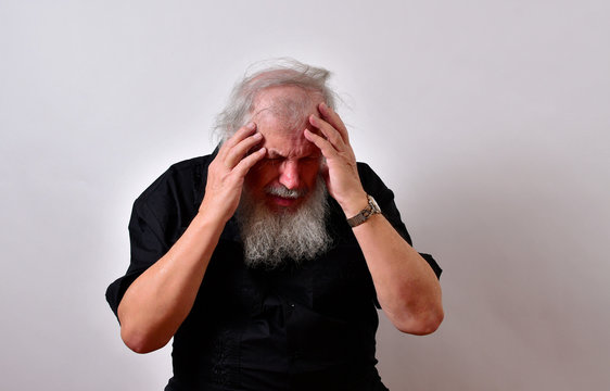 Old man in mental pain.Elderly gentleman is suffering from mental anquish.Senior man in terrific mental pain. .. .Mature gentleman with a newsboy cap and black guayabera shirt and long white beard..