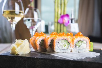 Traditional rolls with fish and rice on a white plate with sauce and wasabi. Japanese food.