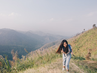 Naklejka na ściany i meble wanderlust and travel concept from Happy asian young woman walking trail in mountain with amazing view. Trekking mountain on National park in Thailand.