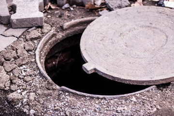 Open sewer manhole and tiles for pavement. Road working. 