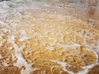 Golden sand and water on the seashore as a background