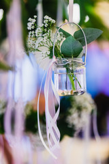 A flower in a glass floating vase on a blue background at a wedding