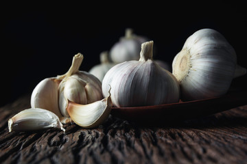 Fresh white garlic on wooden table with black background. Food and healthy concept.