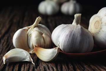 Fresh white garlic on wooden table with black background. Food and healthy concept.