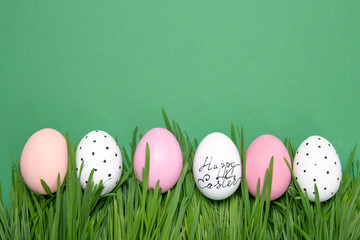 Easter eggs in the grass on a green background, place for text, postcard