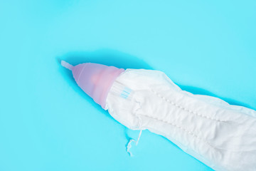 Fototapeta premium Feminine intimate hygiene set over blue background. Sanitary pad, swab or cup. the choice of a modern woman.Red rose. menstrual cycle concept in women