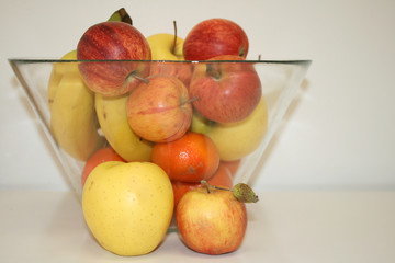 Set of fruits in a bowl and apples red and yellow on her background. 