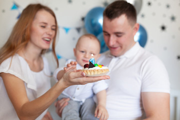 Obraz na płótnie Canvas Portrait of happy mother, father and baby on the background of birthday decorationss