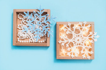 brown gift box and ribbon on a blue background.White crocheted snowflakes and lights. Christmas, party or birthday concept. gift and surprise