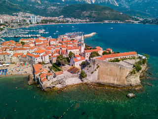 Fototapeta na wymiar Aerial view of Budva, the old city (stari grad) of Budva, Montenegro. Jagged coast on the Adriatic Sea. Center of Montenegrin tourism, well-preserved medieval walled city, sandy beaches