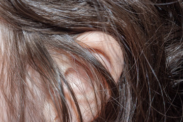 the girl's ear, hidden by disheveled hair