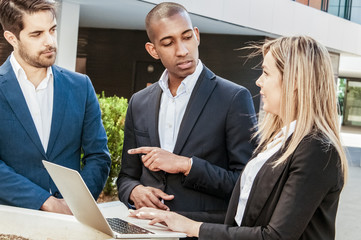 Professionals instructing junior employee. Woman in office suit listening to speaking and gesturing male colleague. Business communication concept