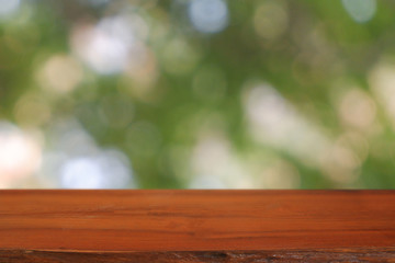 Empty wooden table in front of abstract blurred green bokeh light of garden and nature light background. For montage product display or design key visual layout - Image