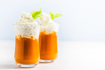 Carrot celery smoothie with coconut whipped cream. Selective focus, copy space.