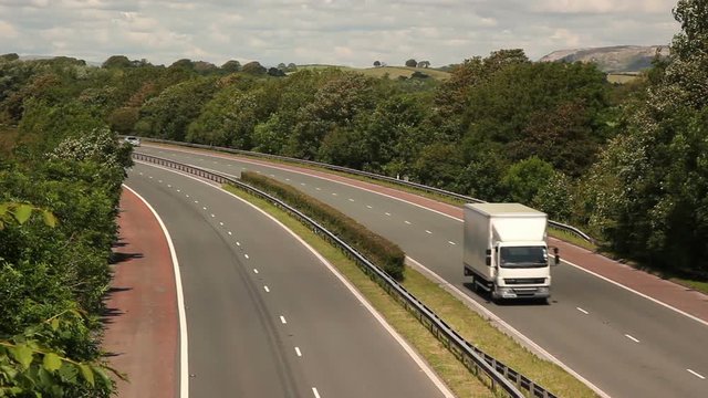 White Truck / Lorry driving on a Dual Carrigeway Road in Summer - Logistics, shipping, Trucking - Stock Video Clip Footage