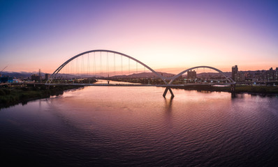 Fototapeta na wymiar Crescent Bridge - landmark of New Taipei, Taiwan with beautiful illumination at day, aerial photography in New Taipei, Taiwan.
