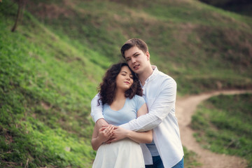 Young couple in love outdoor.Couple posing in summer in field.Smiling couple in love outdoors