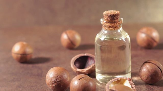 Macadamia oil on wooden table. Healthy concept.