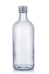 Empty glass bottle with water drops on white background