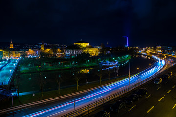Fototapeta na wymiar Germany, Magical night sky over roofs and busy highway street of downtown saarbrucken city by night with clouds, much traffic and starry sky