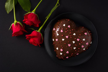 Heart shaped cake and red rose for Valentine's Day or mother's on black background