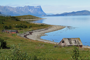 Panorama view of the bay coastline of the beautiful Porsangerfjord at low tide and overcast sky