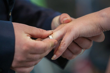 An unrecognizable bride and groom exchanging of the Wedding Rings in church during the christian wedding ceremony 