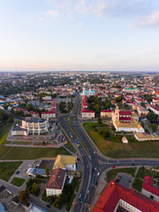 Grodno Regional Drama Theater and Holy Cross Church And Traffic In Mostowaja And Kirova Streets in the morning light. Grodno city in Belarus. Aerial view from a drone.