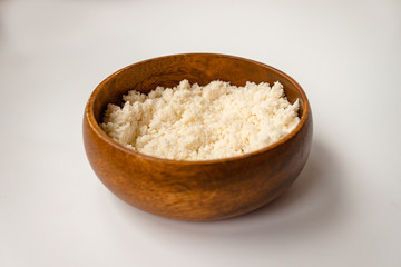 Almond nut crumbs in bamboo wooden bowl on white background isolated