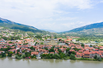 Fototapeta na wymiar Panoramic view of Mtskheta, The Old Town Lies At The Confluence Of The Rivers Mtkvari And Aragvi. Svetitskhoveli Cathedral, Ancient Georgian Orthodox Church, Unesco Heritage In The Center.