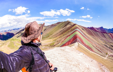 Abenteuerreisender, der Selfie am Rainbow Mountain auf dem Vinicunca-Berg während des Roadtrip-Reiseerlebnisses in Peru macht - Wanderlust-Konzept, das Naturwunder auf der ganzen Welt erkundet - Warmer, lebendiger Filter